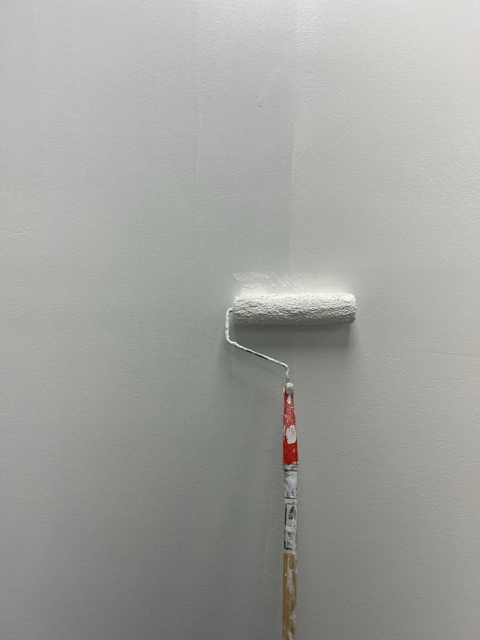 close-up-of-white-paint-roller-on-wall-34046209